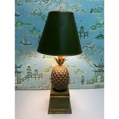 a pineapple lamp sitting on top of a table next to a blue wallpaper