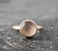 a close up of a ring with a stone in the middle on a rock surface