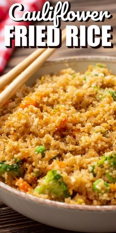 a bowl filled with rice and broccoli next to chopsticks on a table