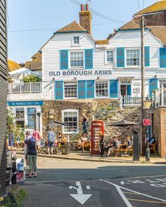 an old borough arms pub on the corner of a street with people walking around it