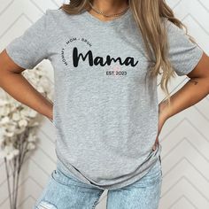 This personalized Mama T-Shirt is the perfect gift for your mom or a soon be a mom. Made from jersey cotton and available in 7 sizes, this comfortable tee is available in white, black, light blue, heather mauve, and athletic heather (grey). * Classic fit * White, Black & Light Blue are 100% Cotton * Athletic Heather is 90% cotton, 10% polyester * Heather Mauve 52% cotton, 48% polyester M E A S U R I N G T I P: Take your favorite tee, lay it flat on a surface and measure from armpit to armpit (width) and top to bottom (length), then compare with our size chart. C A R E I N S T R U C T I O N S: * Machine wash cold, inside out on gentle. Lay flat to dry (or tumble dry on low heat) * Do not iron directly on graphic print. Family Matching Custom Text T-shirt For Personalized Gift, Personalized Name Print T-shirt For Mother's Day, Personalized T-shirt For Mother's Day Gift, Family Matching T-shirt With Custom Text For Personalized Gift, Personalized T-shirt As A Mother's Day Gift, Personalized Family Matching T-shirt With Custom Text, Personalized Family Matching Short Sleeve T-shirt, Custom Text Family Matching T-shirt For Personalized Gift, Mother's Day Personalized Name Print T-shirt