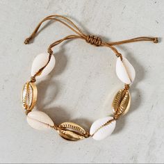 Cowrie Shell Bracelet With Alternating Natural And Gold Shells. Adjustable Cord Closure For All Your Boho Needs. Carefully Sourced For The Highest Quality Materials And Craftsmanship. These Shell Pieces Are Expertly Crafted And Lay Beautifully Without Turning As Many Of The Cheaper Alternatives Do. Adjustable Boho Elegant Adjustable Bracelets For Beach, Elegant Adjustable Beach Bracelets, Elegant Adjustable Bracelets For Vacation, Beige Bracelets For Beach, Beach Jewelry In Beige With Adjustable Length, Adjustable Beige Jewelry For The Beach, Adjustable Beige Jewelry For Vacation, Beige Adjustable Beach Jewelry, Gold Jewelry With Adjustable Length For Vacation