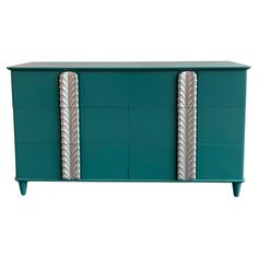 a green dresser with two metal handles on it