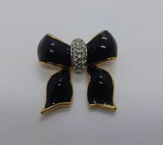 you are purchasing a Ribbon Pin Vintage Pin Gold and Black Bow Brooch Pin Rhinestone Diamond Costume Jewellery Jewelry  Ribbon Bow a delightful pin brooch in the shape of a bow for your consideration, the ideal gift for a loved one.  Approx 1980s No makers mark. Although it's a high quality item. Gold coated metal. Perfect finishing detail to any outfit. Measurements: 2.5 inches in length  Lovely overall condition. [Shipping] You will receive a tracking number with this purchase. The item will b Black Brooch With Decorative Bow Gift, Black Brooch With Decorative Bow As Gift, Formal Black Brooch With Decorative Bow, Black Brooch Pins For Party, Black Party Brooch Pins, Vintage Black Party Pins, Black Brooch With Decorative Bow For Evening, Black Brooch Pins For Evening, Diamond Costume