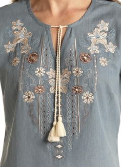 This beautiful baby blue short sleeve, light weight top has beautiful embroidered flowers in tan, brown, and cream and a cute tassel tie at the v-neck. 100% Cotton Casual Blue Tops With Tassel Ties, Summer Brown Blouse With Floral Embroidery, Light Blue Floral Embroidered V-neck Top, Blue Spring Tops With Tassel Ties, Light Blue Embroidered V-neck Top, Blue Spring Top With Tassel Ties, Casual Short Sleeve Tops With Tassel Ties, Spring Blouse With Tassel Ties And Short Sleeves, Spring Blouse With Short Sleeves And Tassel Ties