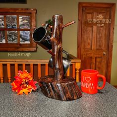 there is a coffee cup and mug holder on the counter next to a tree stump