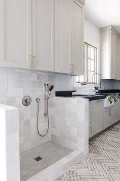 a bathroom with white cabinets and black counter tops is featured on the instagram page