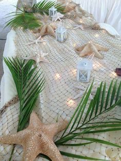 a starfish is laying on a table with some lights and palm leaves around it