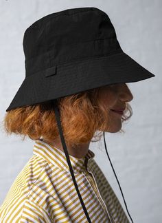 Rain or shine. the wide brim bucket hat is a fresh take on the iconic fisherman’s hat. constructed from a double layered pu coated technical fabric with a brushed finish for durability water repellency and quick drying. enjoy design details such as a slightly elevated crown groisgrain ribbon tab and removable chin straps. this hat is unisex.    made in usa    - fitted  - 100% nylon  - pu coated technical fabric  - grosgrain ribbon detail  - water repellent  - stitched wide brim  - tonal chin straps  - interior loops for detachable cord ties  - size s – 23″ circumference  - size l – 24 1/2″ circumference Wide Brim Bucket Hat, Cord Ties, Bucket Hat Black, Rain Or Shine, Wide Brimmed, Grosgrain Ribbon, Water Repellent, Designing Women, Design Details