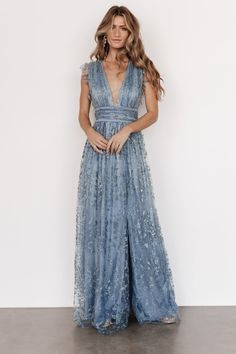 Femme portant une robe longue bleu clair avec des motifs floraux délicats. Blue Maxi Wedding Guest Dress, Baby Blue Flowy Dress, Boho Blue Bridesmaid Dresses, Blue Sparkle Bridesmaid Dress, Dusty Blue Plus Size Dress, White Dress With Blue Accents, Steel Blue Maxi Dress, Floor Length Blue Dress, Modern Fairytale Dress