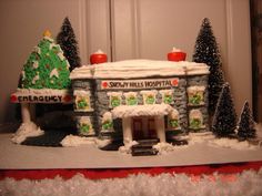 a snow covered building with trees and lights on it's front door is shown