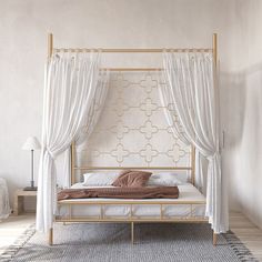 a white bed with curtains and pillows in a room