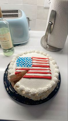 a cake with an american flag frosting on it next to a toaster and bottle of wine