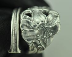 a close up view of a silver ring with flowers on it