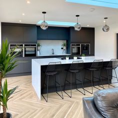 a modern kitchen with an island and bar stools