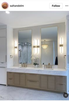 a bathroom with two sinks and three mirrors