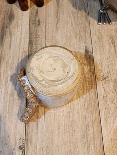 a wooden table topped with a metal cup filled with liquid