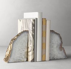 three books are stacked on top of each other in front of a white background with gold accents