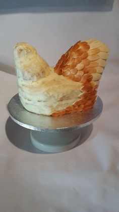 there is a cake shaped like an owl on a plate with wings flying around it