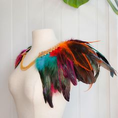 A one-off, hand-made, feather collar that sits over the shoulders and fastens at the front with a gold-coloured necklace. This collar has multiple layers of feathers in shades of burgundy, purple, blue, yellow, green, and black, plus a delicate gold trim that sits around the neckline. It will add extra flair to your outfit, whether that is for a special occasion, Halloween party, festival, performance, or just doing the housework!  This collar is comfortable to wear and should fit most neck size Feather Collar, Shades Of Burgundy, Bib Collar, Decorative Trim, Party Festival, A Necklace, Fete Halloween, Colourful Necklace, Gold Trim