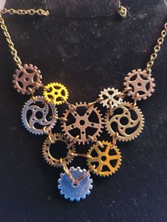 A steampunk bib gear necklace handmade with 10 gears connected by interlocking copper wire. Steampunk Gold Copper Jewelry, Steampunk Gold Jewelry With Copper, Gold Steampunk Jewelry With Copper, Gold Steampunk Jewelry Made Of Copper, Steampunk Style Metal Necklace With Adjustable Chain, Handmade Bronze Steampunk Necklace, Steampunk Necklace With Adjustable Metal Chain, Steampunk Metal Necklace With Adjustable Chain, Gold Steampunk Necklaces