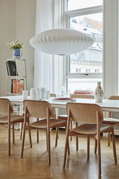 a dining room table and chairs in front of a large window