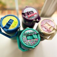 four different colored tape dispensers sitting on top of a table next to each other