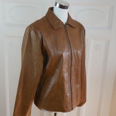 This 1980s honey brown leather jacket has a wing collar and lightly padded shoulders and zips closed in front. The stunning Italian vintage jacket has two hand-warmer pockets on the front and is lined in a bronze satin polyester fabric. Size: 10 US, 14 UK Bust = 40 inches (101.6cm) (The industry standard for sizing women's jackets/coats is to allow 2 inches extra in the bust to allow for what you wear under and ease of movement; so this is a best fit for a 38-inch bust, or Size 10 US.) Shoulders Vintage Leather Jacket With Zipper For Work, Vintage Brown Leather Jacket With Zipper Closure, Vintage Brown Leather Jacket With Zipper, Vintage Brown Outerwear With Zipper Closure, Vintage Brown Outerwear With Zip Fly, Vintage Brown Leather Jacket With Zip Fly, Wing Collar, A Wing, Uk Photos