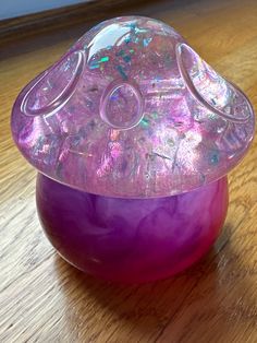 a purple object sitting on top of a wooden table