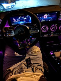 a person sitting in the drivers seat of a car with their feet on the steering wheel