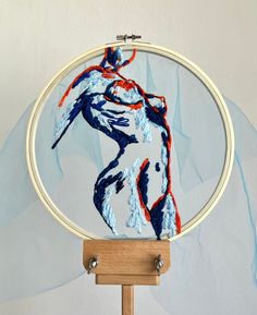 an embroidery project featuring a woman's torso in red, white and blue colors