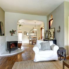 a living room filled with furniture and a fire place in the middle of a room