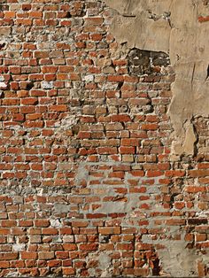 an old brick wall with peeling paint on it