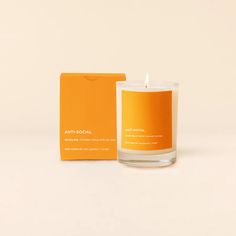 an orange candle sitting next to a box