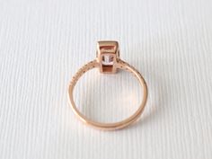 14K rose gold bezel ring featuring a natural emerald cut champagne pink sapphire measuring 8.5 x 4.2 mm and weighing 1.08 ct. (VS). This beautiful gem is further adorned and complimented by round brilliant cut diamonds with a total weight of 0.15 ct.. (G,VS2/SI1) 2.0 mm comfort fit band, size 6, can be sized up to 8. Original Studio 1040 design. *Ready to ship SKU 5-100117 Gemstone Stacking Ring, Half Eternity Ring Diamond, Pink Emerald, Champagne Pink, Statement Rings Diamond, Full Eternity Ring, Bezel Ring, Right Hand Rings, Half Eternity Ring