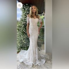 a woman in a white wedding dress posing for the camera with her hands on her hips