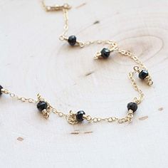 "Scattered Spinel Gemstone Necklace The most tiny & dainty everyday necklace. Featuring seven tiny black spinel rondelles (~4mm each) that are hand wrapped to the most delicate & shimmering 14k gold fill chain. A gorgeous necklace that you will reach for everyday.. Necklace measure 17 inches as pictured. Completed with a round spring clasp. ♥Your purchase will come thoughtfully packaged and ready for gift giving. If this purchase is a gift that we are shipping directly to the recipient, Gift Necklace With Black Spinel And Beads, Gift Black Spinel Necklace With Black Beads, Black Spinel Necklace With Black Beads For Gift, Black Spinel Beaded Necklace For Gifts, Minimalist Black Spinel Necklace As Gift, Dainty Jewelry With Black Beads For Gifts, Dainty Jewelry With Black Beads As A Gift, Dainty Black Beaded Jewelry As A Gift, Dainty Jewelry With Black Beads