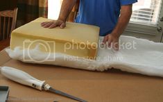 a man cutting cheese on top of a table