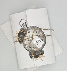 two cards with an image of a pocket watch tied to twine on top of each other