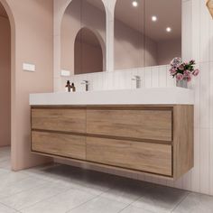 a bathroom with a sink, mirror and vase on the counter in front of it