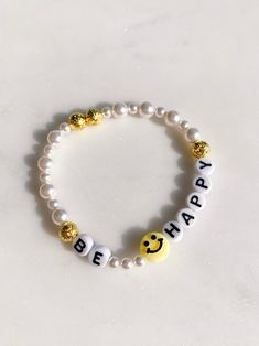 A smiley face and pearls...can't go wrong! Stack it with others or wear it alone and this bracelet will make you smile every time you look at it. stretchy one size made locally! All accessories are final sale. Be Happy Bracelet, Friendship Bracelets Smiley Face, Cheap Yellow Beaded Bracelet With Smiley Face, Bracelet With Words Ideas, Smile Face Bracelet, Beaded Bracelets Cute, Casual Gold Pearl Bracelet, Trendy Everyday Bracelet With Smiley Face, Trendy Everyday Bracelets With Smiley Face