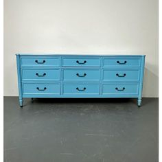 a blue dresser sitting on top of a gray floor