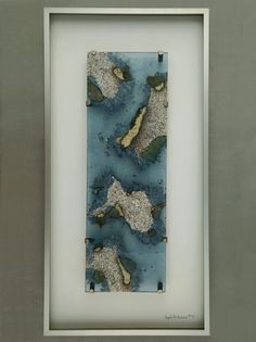 an abstract painting in a white frame with blue and green paint on it's surface