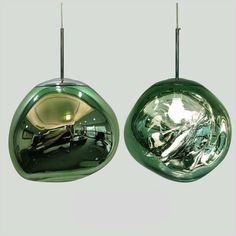 there are two green lights hanging from the same light fixture, one is shiny and the other is chrome