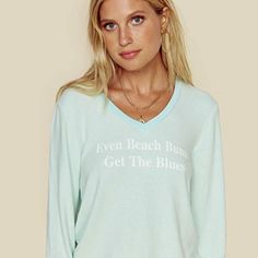 Aqua / Light Mint V-Neck Sweatshirt With White 'Even Beach Bums Get The Blues' Text Graphic By Wildfox. New With Tags. Size Medium. Approximate Measurements: Bust 19.5" Length 23" Relaxed Long Sleeve Tops For Summer, Relaxed Fit Long Sleeve Beachy Tops, Beachy Relaxed Fit Long Sleeve Tops, Beachy Long Sleeve Relaxed Fit Top, Blue Tops For Loungewear During Beach Season, Relaxed Fit V-neck Top For Lounging, Long Sleeve Tops For Summer Lounging, Cotton V-neck Tops For Lounging, Crew Neck Tops For Beach Loungewear