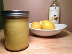 two lemons sit next to a jar of honey on a table