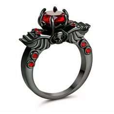 Brand New 18kt Red Ruby Black Gold Skull Wings Ring. Reviving And Epic, This High Fashion Classic Winged Skull Ruby Solitaire Engagement Ring Evokes Character And Elegance Making This Designer Jewelry Piece An Excellent Engagement Ring, Wedding Ring Or A Great Gift You Can Buy For Yourself. Stone Settings In Pave, Prongs, Bezel, Channel Or Invisible May Differ Slightly As The Stones Are Set By Hand. Edgy Skull Ring Gift, Punk Black Ring For Halloween, Black Punk Rings For Halloween, Punk Black Rings For Halloween, Black Skull Ring For Halloween, Gothic Black Skull Ring For Halloween, Edgy Halloween Rings For Gift, Halloween Black Skull Ring, Black Skull Rings In Punk Style