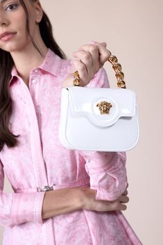 Versace la medusa mini bag in optic white. 100% Calf leather, Lining: 100% Nappa leather Length: 16cm x Width: 6cm x Height: 12cm Fits Iphone 15 Pro Max Made in IT White Party Bags With Gold-tone Hardware, Luxury White Clutch Shoulder Bag, White Luxury Clutch Bag, Luxury White Clutch Bag, White Top Handle Bag With Chain Strap, Trendy White Shoulder Bag With Round Handle, White Leather Party Bags, Designer White Bag With Round Handle, White Luxury Shoulder Bag For Party