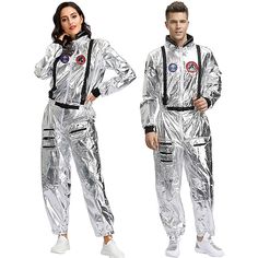 two people in silver space suits standing next to each other and posing for the camera