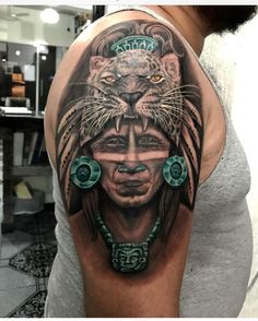 a man with a tattoo on his arm has a lion and woman's head